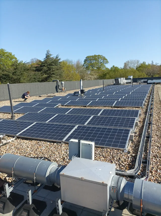 Engineer inspecting rooftop solar panels for carbon reduction and net zero compliance