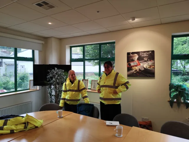 Sustainability consultants wearing high-visibility clothing during an industrial project visit