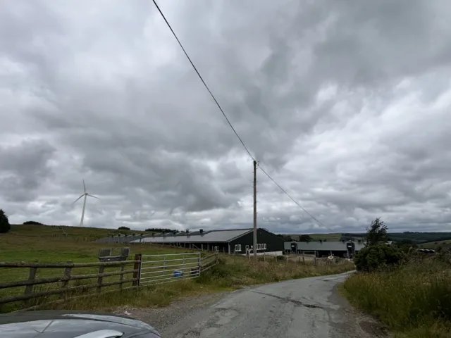Wind turbine beside agricultural buildings supporting carbon reduction and net zero planning