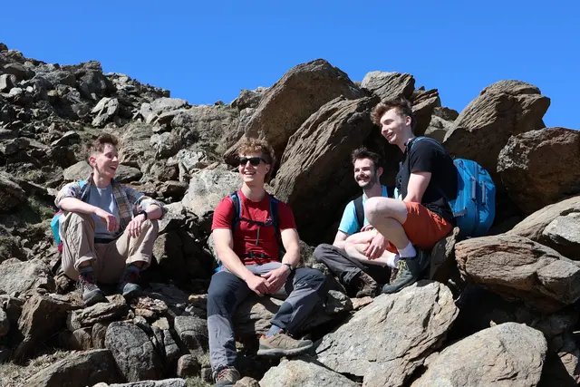 Four colleagues taking a break during a mountain walk